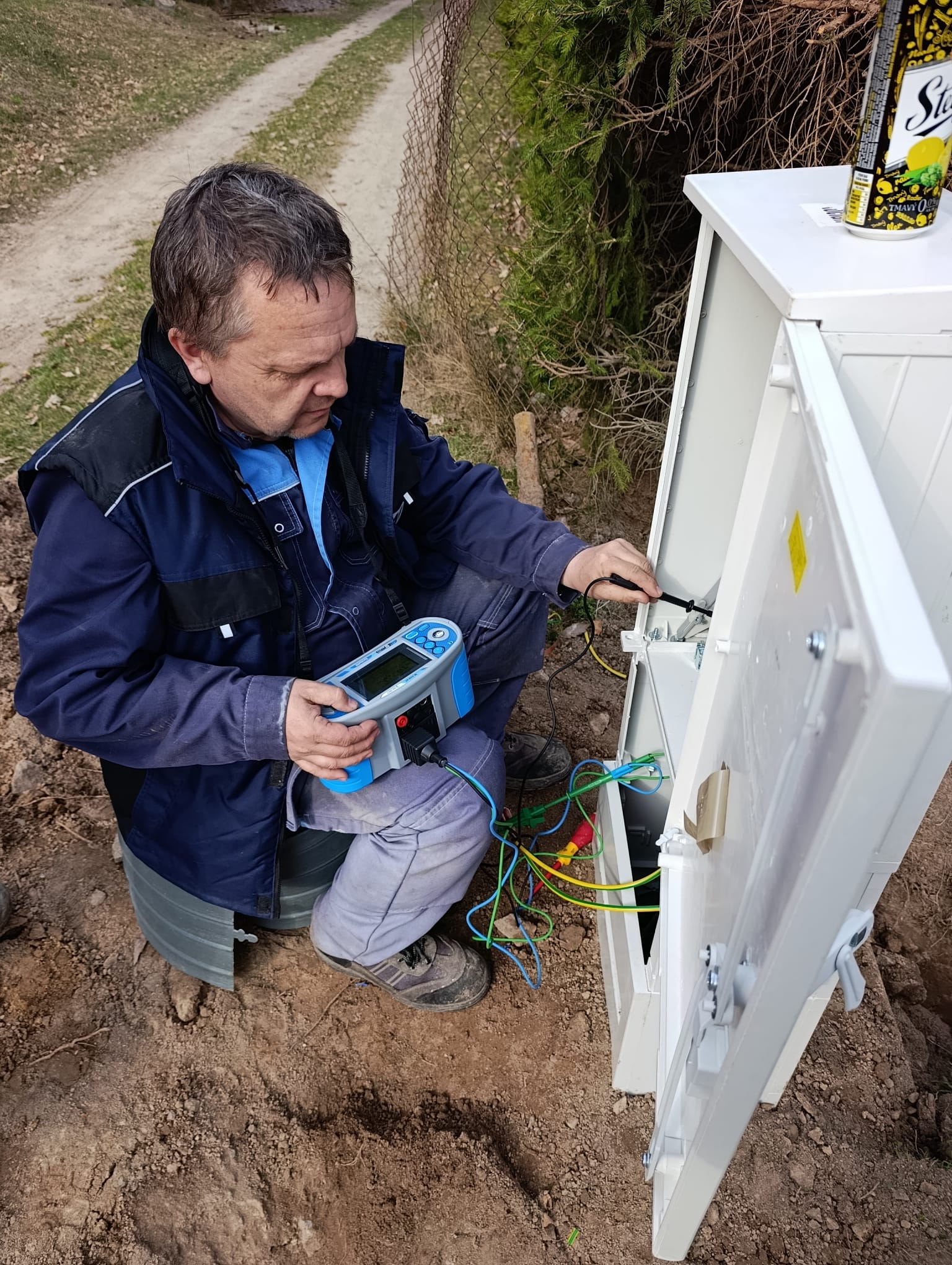 Elektrikár pri inštalácii kabeláže na strope